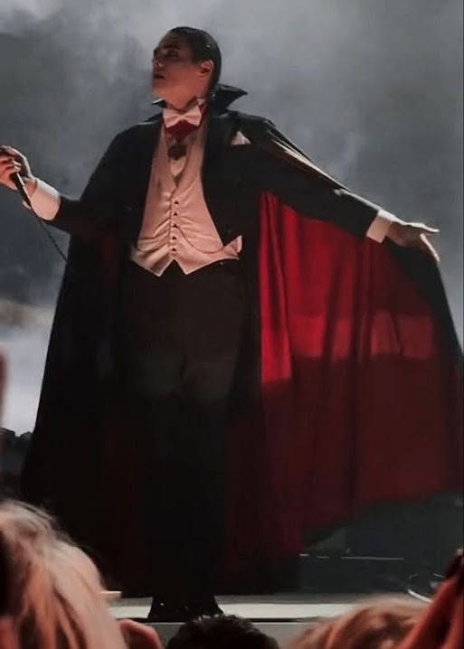 Inspiration déguisement : vampire sur scène avec cape rouge